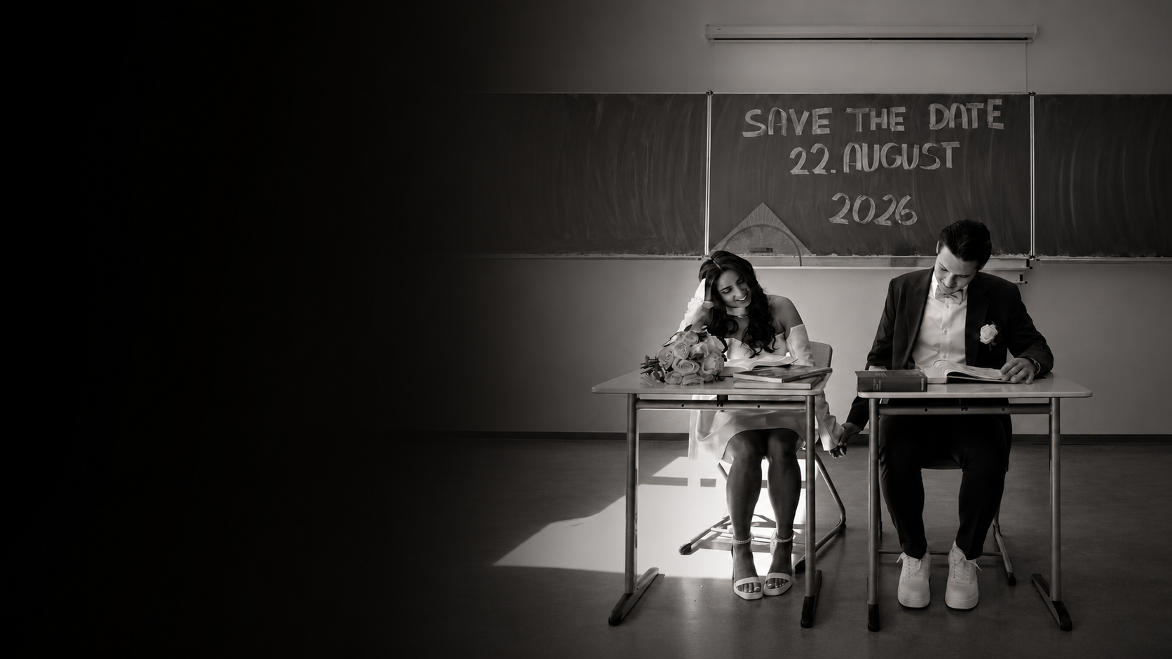 Daniel und Francesca sitzen vor einer Save-the-Date Tafel.